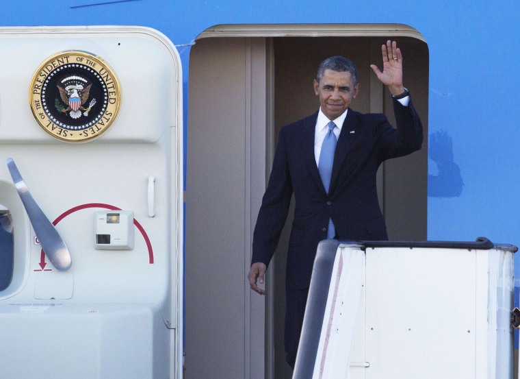 Image: President Barack Obama waves as he disembarks from Air Force One upon his arrival in Amsterdam