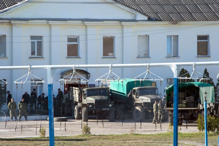 Image: Ukrainian soldiers load weapons and ammunition into trucks in the Crimean city of Feodosia