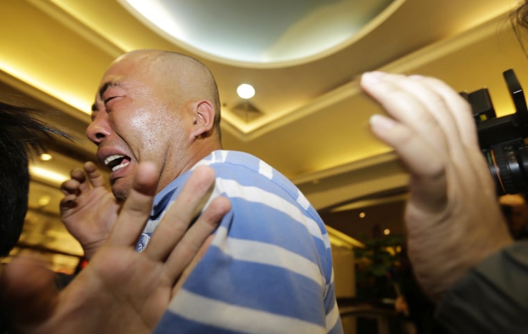 Image: Relatives of passengers aboard Malaysia Airlines MH370 cry after watching a television broadcast of a news conference, in the Lido hotel in Beijing