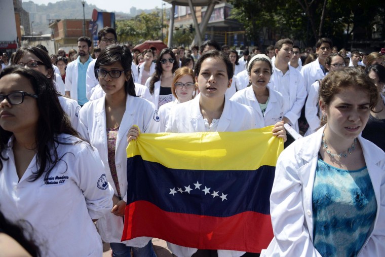 Medical students from the Venezuelan Central University attend an open air masterclass at a square as a protest for the lack of medical supplies, in Caracas on March 24, 2014.