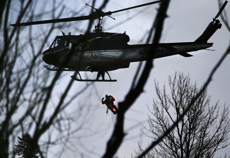 Image: A King County Sheriff helicopter lowers a rescuer