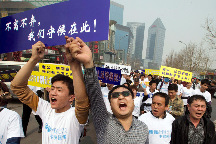 Image: Chinese relatives of passengers onboard the missing Malaysia Airlines plane, flight MH370, shout in protest