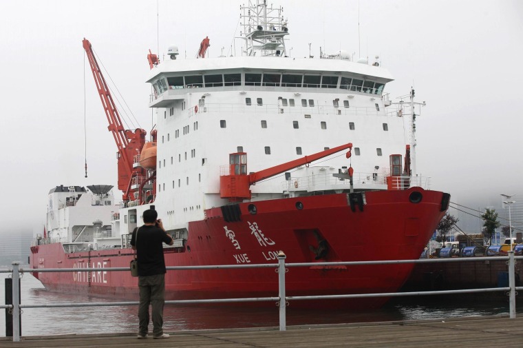 Image: A man takes a photo of Chinese icebreaker Xuelong