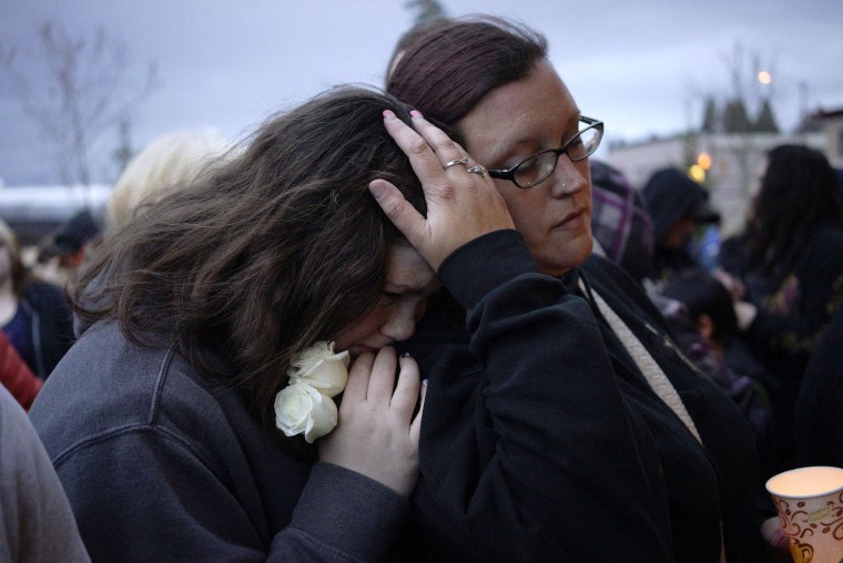 Image: Sarah Halstead comforts her daughter Allison at a candlelight vigil for mudslide victims in Arlington