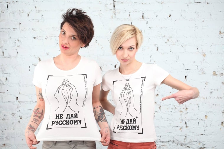 Women model the "Don't give it to a Russian" T-shirts on the group's Facebook page.