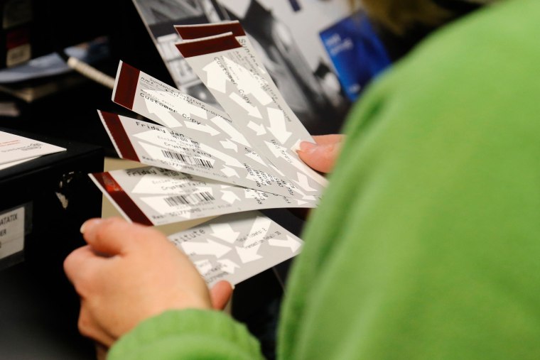 Image: A person holds movie tickets inside the box office