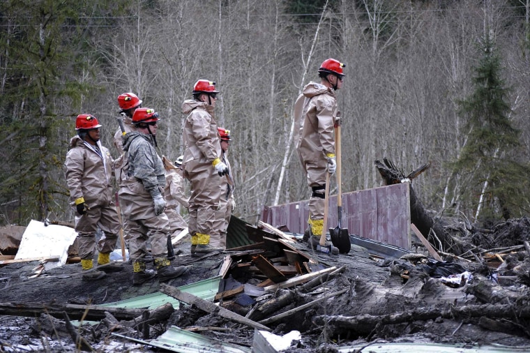 Image: Air Force personnel join civilian workers in efforts to find missing persons following a deadly mudslide in Oso