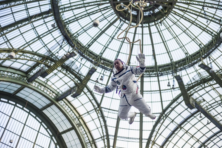 Image: Chinese artist Li Wei performs dressed as an astronaut at the Grand Palais, in Paris, France