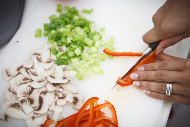 Image: A woman prepares vegetables