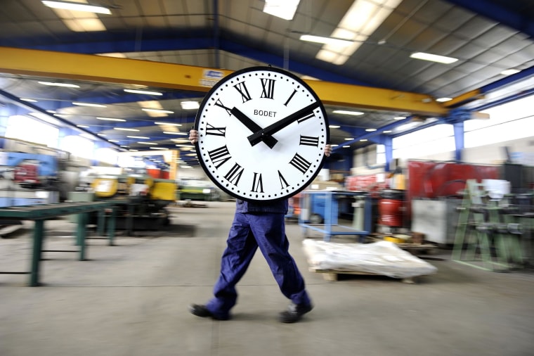 Image: An employee of the Bodet Company carries a clock