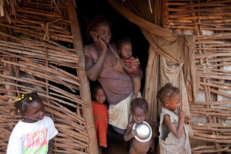 Image:  Jeanilia Jean-Baptiste 38, stands in the entrance of her home, surrounded by 5 of her children, during an interview in Bombardopolis, Haiti.