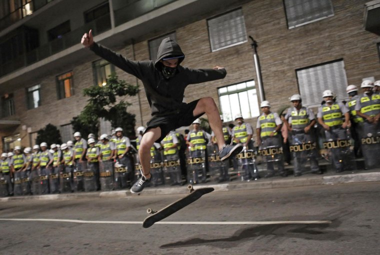 A demonstrator performs a trick with his skateboard in front of military police during a protest against the 2014 World Cup in Sao Paulo on Friday. Protesters are angry that billions of dollars worth of public funds have been spent on 12 stadiums for the cup, which kicks off in São Paulo June 12. 
