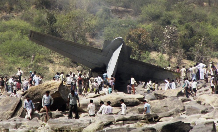 Image: Onlookers stand next to the debris of a crashed Indian Air Force C-130J Hercules aircraft in Madhya Pradesh