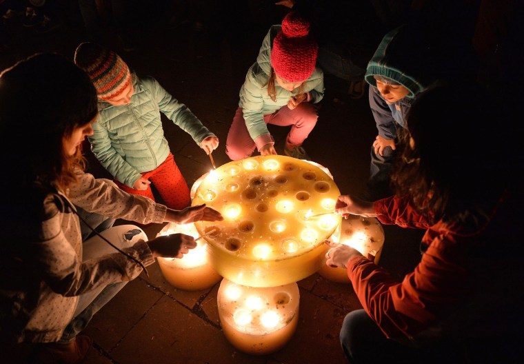 Image: People light candles to celebrate Earth Hour in a park in Bucharest