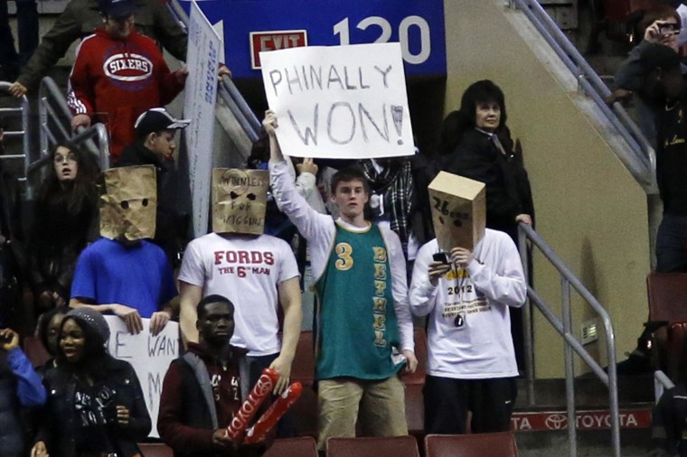 Image: Fans hold signs after the Philadelphia 76ers won an NBA basketball game against the Detroit Pistons