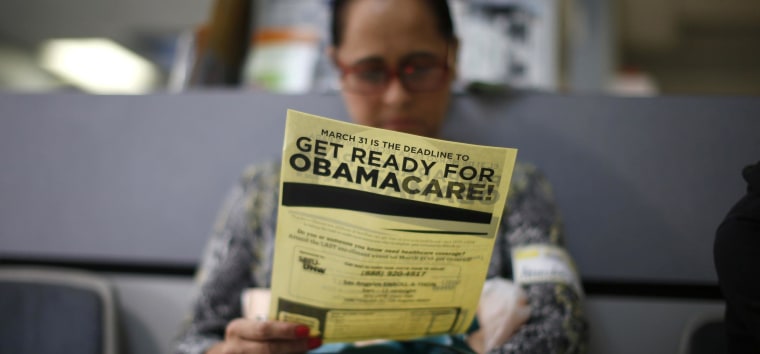 Image: Murillo reads a leaflet at a health insurance enrollment event in Cudahy, California