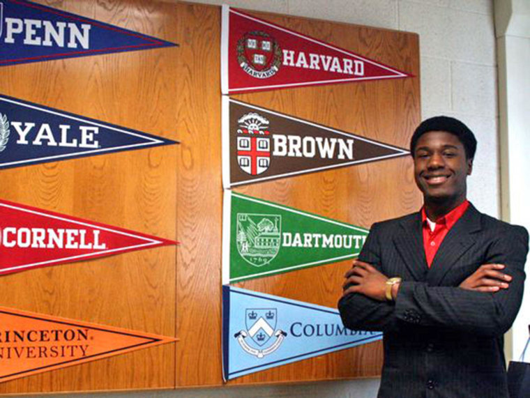 Kwasi Enin poses with banners from the Ivy League colleges where he was accepted.