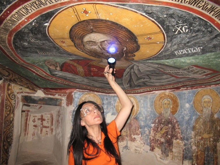 Image: UCLA archaeologist Ioanna Kakoulli examines a painting in the monastery under UV light