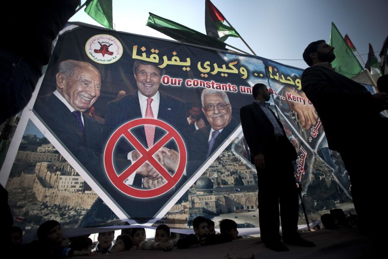 Image: Palestinian protesters stand in front of a giant banner showing Secretary of State John Kerry