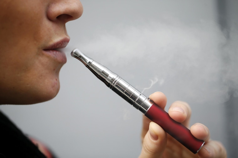 Image: A person smokes an electronic cigarette