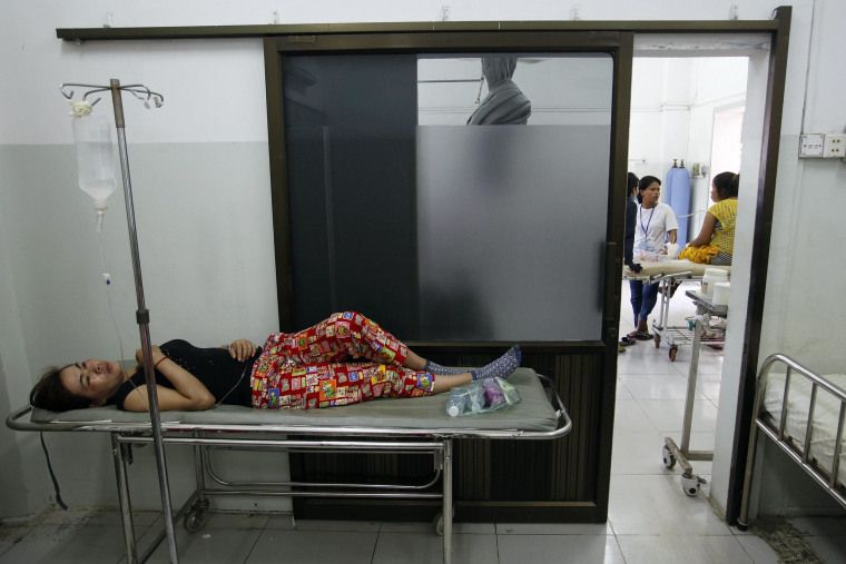 A garment worker recovers at a hospital after fainting at a factory in Phnom Penh April 3, 2014.