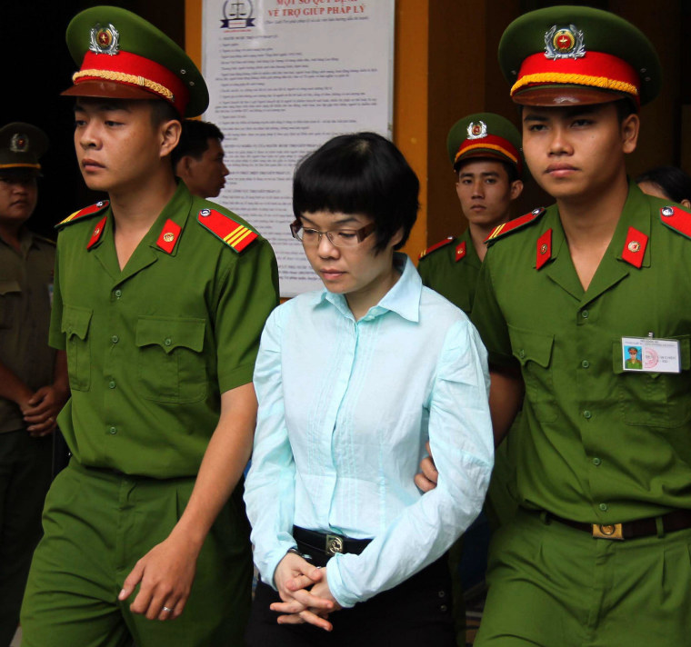 Image: Huynh Thi Huyen Nhu, 37, is led out of the courtroom at a local People's Court House in Ho Chi Minh City
