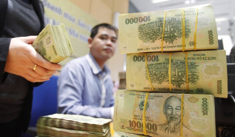 Image: Employees count money at a branch of the BIDV in Hanoi