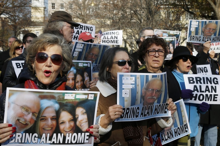 Image: Supporters of Alan Gross, seen on posters, hold an event to mark his fourth year in prison in Cuba