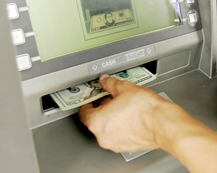 A customer withdraws money from an ATM machine in Miami Springs, Florida, on Sept. 26, 2008.