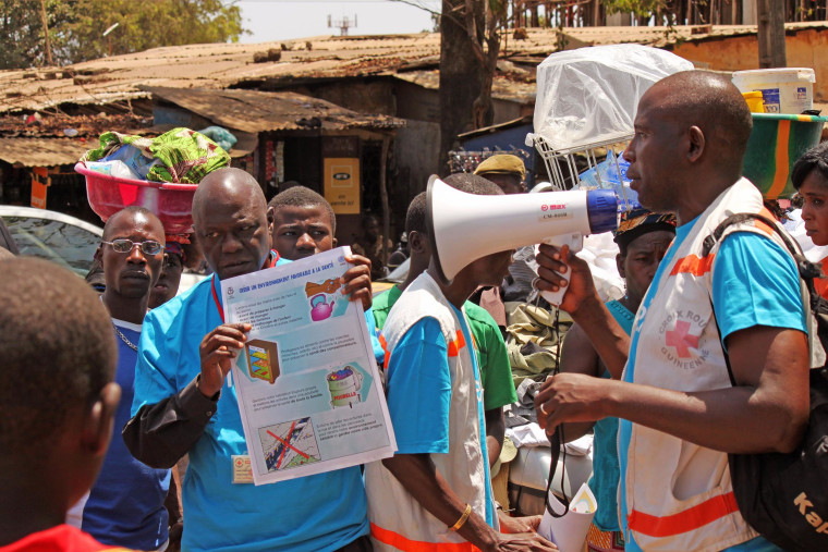 Image: Health workers teach people about the Ebola virus in Guinea