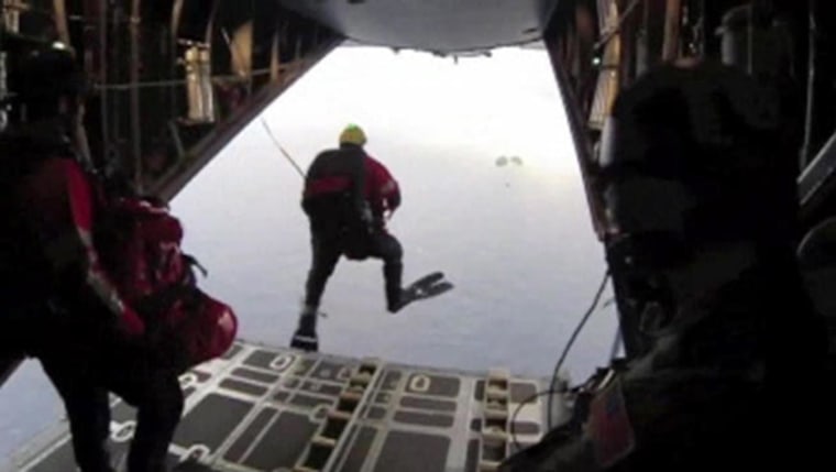 Image: Four pararescuers jump out of an airplane to rescue a child on sailboat