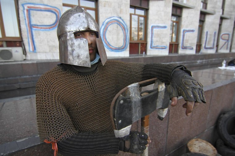 Image: A man is seen wearing medieval armour as pro-Russian protesters gather outside a regional government building in Donetsk