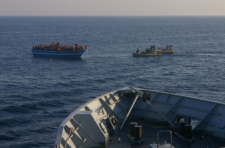 Image: Italian Navy dinghies approach a boat carrying migrants off the Sicilian island of Lampedusa