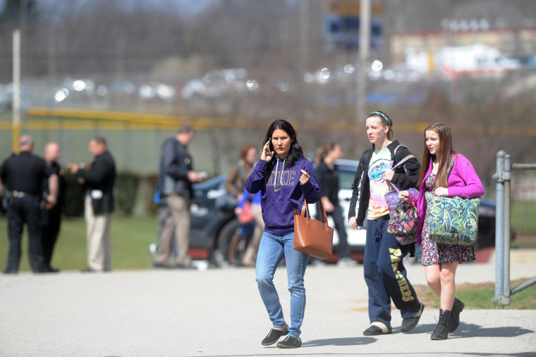 Image: Parents and children are reunited at an organized pickup for parents at the Elementary School following a stabbing spree at Franklin Regional Senior High School