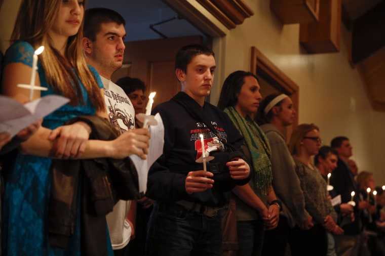 Image: People hold candles during a prayer vigil for victims of the Franklin Regional High School stabbing rampage, at a church in Murrysville