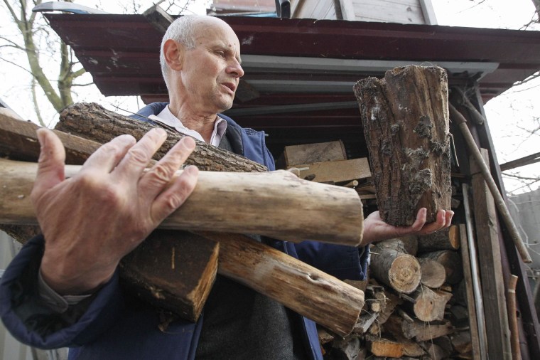 Image: Shevchenko carries firewood to his house in the village of Zazimye