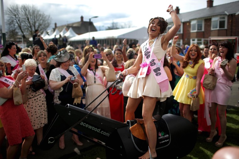 Bride-to-be Gemma Blease enjoys a ride on a horse racing simulator as she and her hen party enjoy the atmosphere of Ladies Day at the Aintree Grand National Festival on April 4, 2014 in Aintree, England. Friday is traditionally Ladies Day at the three-day meeting of the world famous horse race where fashion and dressing to impress is as important as the racing. 