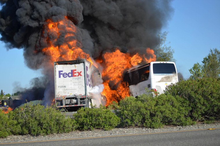 Image: Massive flames are seen devouring both vehicles just after a crash involving a FedEx tractor-trailer and a bus