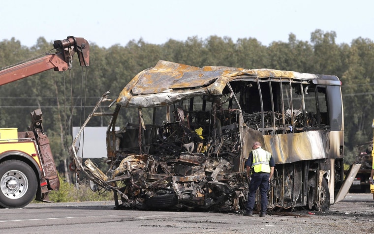 Image: A California Highway Patrol Officer looks over the burned out remains of a tour bus on Friday that collided with a FedEX truck on Interstate 5 Thursday in Orland, Calif.