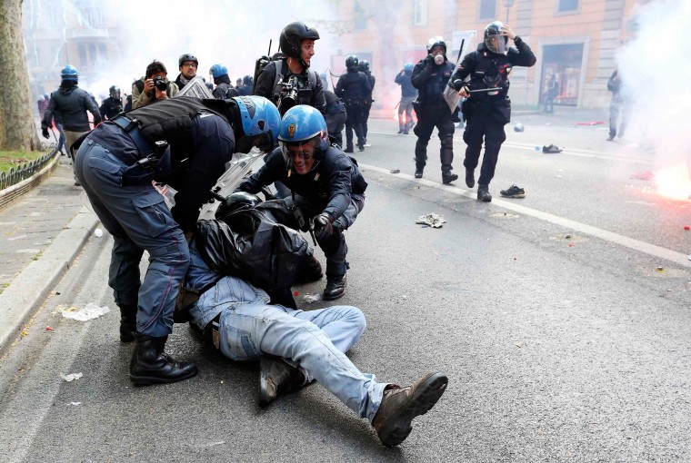 Image: A demonstrator is detained by policemen during a protest in downtown Rome