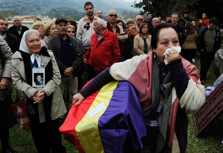 Image: Juana Gutierrez cries while holding the remains of her grandfather, a victim of Spain's Civil War, in the cemetery of Valdenoceda