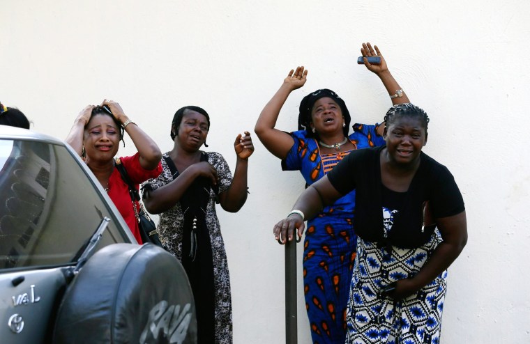 Image: Bystanders react as victims of a bomb blast arrive at the Asokoro General Hospital in Abuja