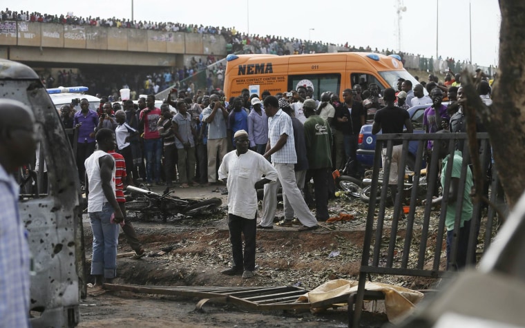 Image: Crowd gather at the scene of a bomb blast at a bus terminal in Nyayan, Abuja