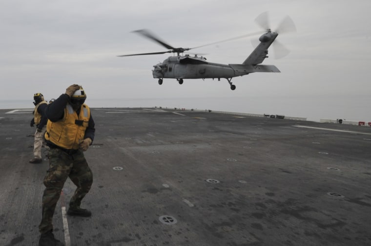 An MH-60S Sea Hawk helicopter lands on the flight deck of the forward-deployed amphibious assault ship USS Bonhomme Richard