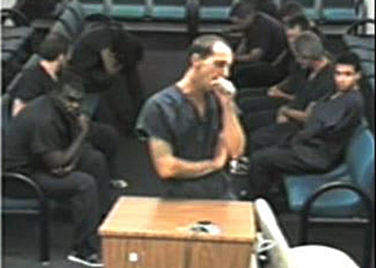 A suspect yawns as he appears before a judge in South Florida.
