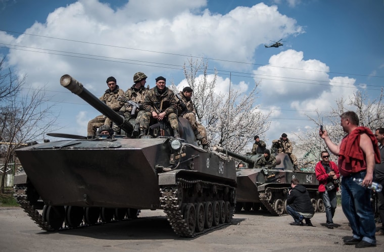 Image: Pro-Russian protesters take photos of Ukrainian soldiers sitting on their armored vehicle in Kramatorsk, Ukraine