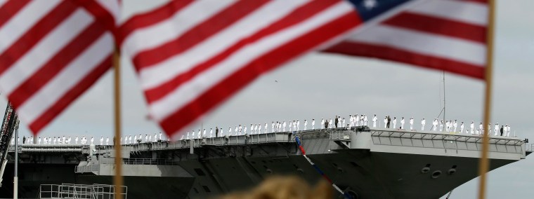 Image: Sailors man the rails as the nuclear aircraft carrier Harry S. Truman approaches the pier at Naval Station Norfolk in Norfolk, Va.