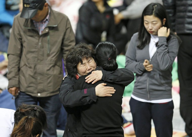 Image: Family members of missing passengers of the Sewol ferry comfort each other Saturday as they wait news about their missing relatives at a gym in Jindo, South Korea.