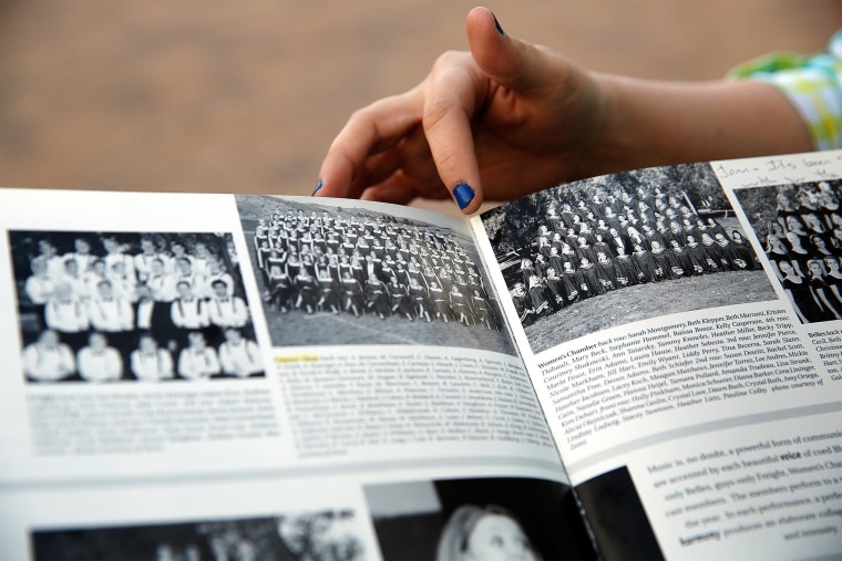Image: Former Columbine High School student Jennifer Hammer points out the choir group picture in her yearbook to Heather Egeland at the Columbine Memorial