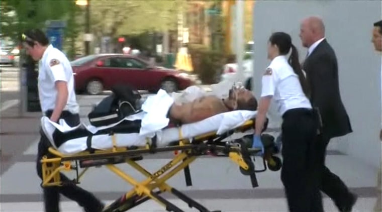 Image: An injured man is wheeled to an ambulance following a shooting at the new Fereral Courthouse in Salt Lake City, Utah.